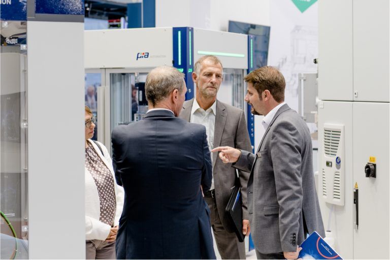Besucher im Gespräch bei PIA Automation Messestand